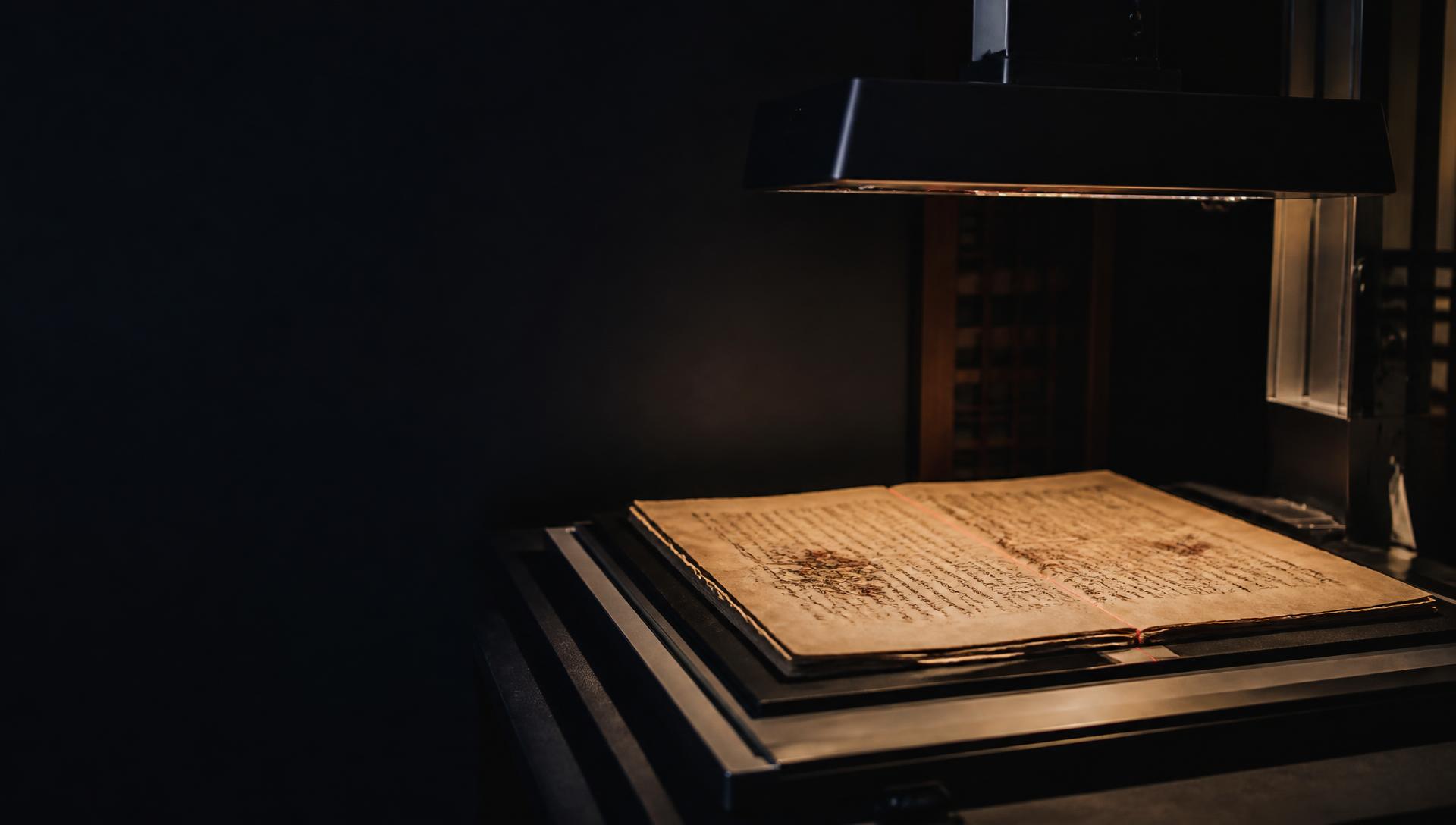 Historical manuscript beneath an archival scanner